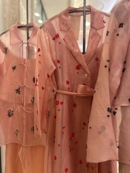A trio of sheer pink co-ord sets, each with a unique style of floral embroidery, from red hearts to black and silver motifs.
