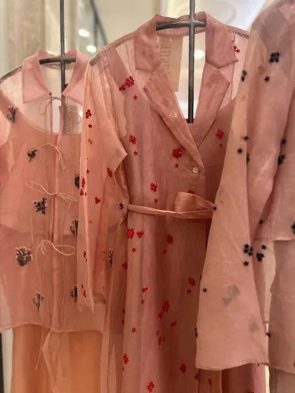A trio of sheer pink co-ord sets, each with a unique style of floral embroidery, from red hearts to black and silver motifs.