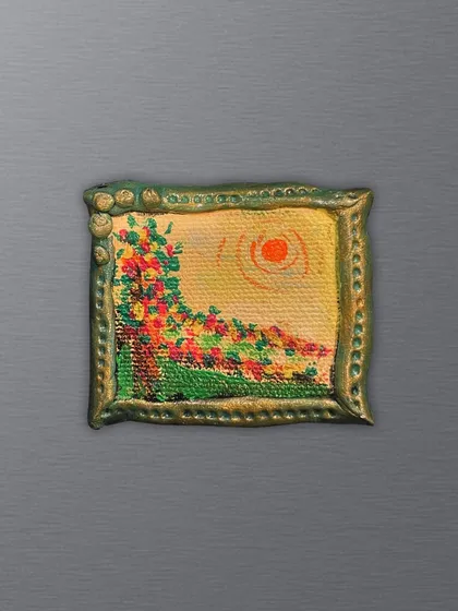 A tiny landscape painting you can hold. This magnet captures a colorful sunset over a field of flowers, framed by a hand-sculpted green border.