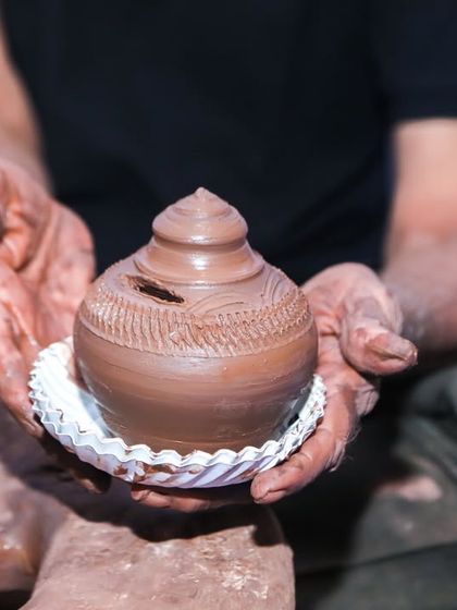 A professional potter demonstrates how to shape clay on a pottery wheel, a fascinating and tactile experience for all ages.