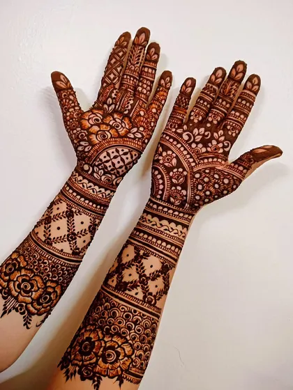 A classic bridal henna design with bands of different patterns. This style includes floral work, netting, and traditional Indian motifs.