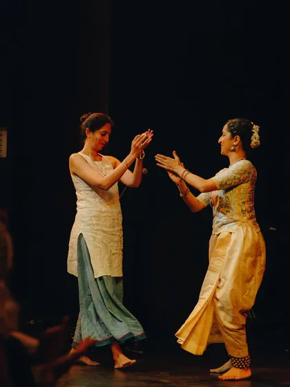 A candid moment of shared joy on stage. The collaborative process extends beyond the formal performance into these small, unscripted interactions.