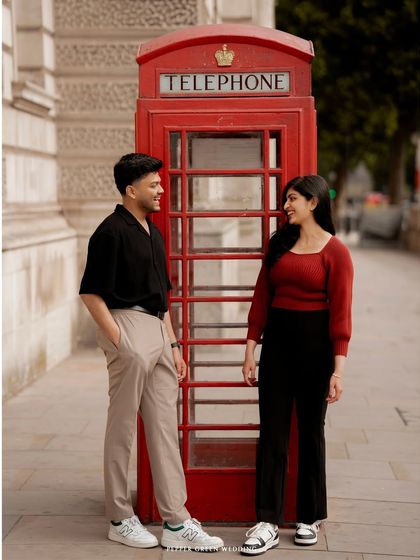 A classic London telephone booth provides a pop of color for this stylish couple's pre-wedding portrait. These sessions are a wonderful opportunity to showcase your personality and style.