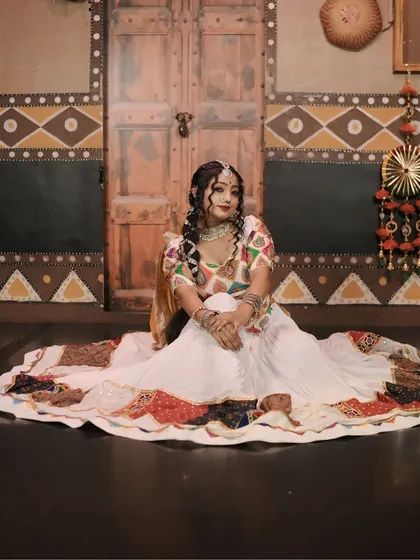 Another seated pose from the 'Gori Radha' shoot, showing the full spread of the beautiful white and multi-colored ghagra.