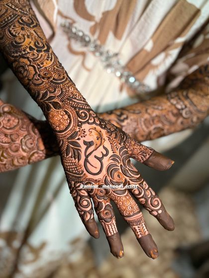 A close-up of the Om symbol, drawn with care and respect, as the centerpiece of the palm design.