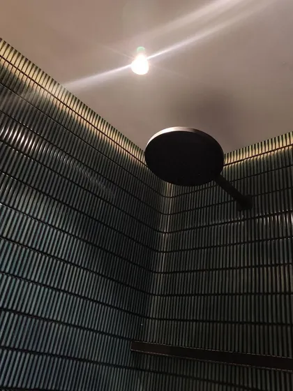 A close-up of a material and lighting mockup on site. We believe in a hands-on process, and testing how materials like these ribbed tiles interact with light is a critical step to achieving the perfect sensory effect.