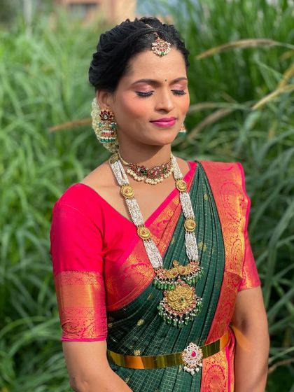 A close-up of Vanitha's makeup, with striking pink eyeshadow and a matching lip color.