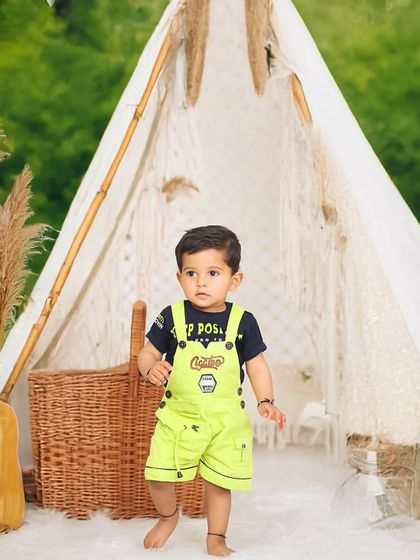 This outdoor session features a full boho setup with a macrame teepee and lanterns against a lush green backdrop, showing how I can bring studio creativity to the outdoors.