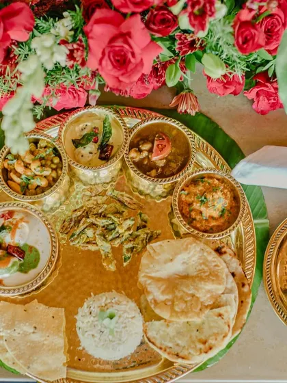 We believe in the beauty of tradition. This overhead view captures our meticulously arranged Jain thaali, a complete sensory journey through authentic Indian flavours, presented with modern elegance.