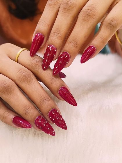 Another shot of the fierce red stiletto nails, showing off the sharp shape and the intricate texture of the beaded accent nails.