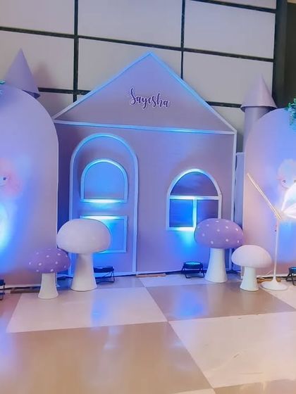 A beautiful fairy castle setup in pastel purple. This decoration features a custom-built castle backdrop, glowing butterfly wing props, and soft balloon clouds, perfect for a little one's magical birthday.