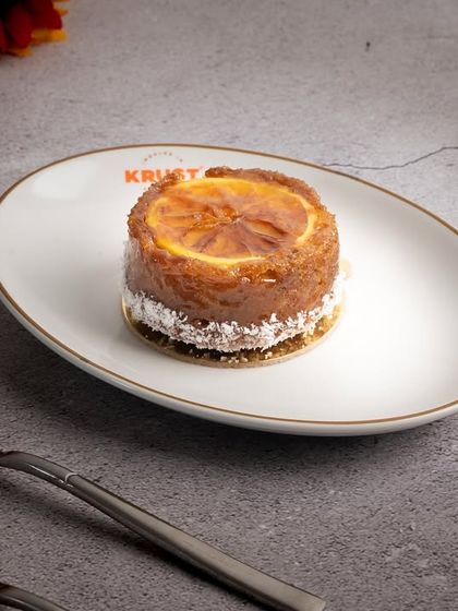 A plated Orange Ginger Tea Cake, showing its delicate size and beautiful presentation. It's one of my signature items that I highly recommend.