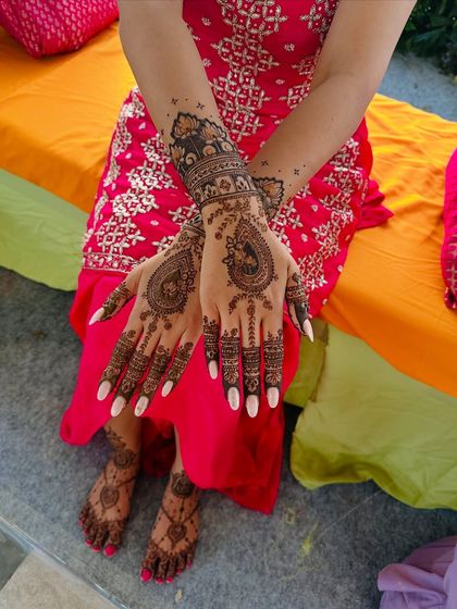This design features bold paisley and peacock motifs on the hands, with complementary patterns on the feet. The combination creates a striking and beautiful full bridal look.