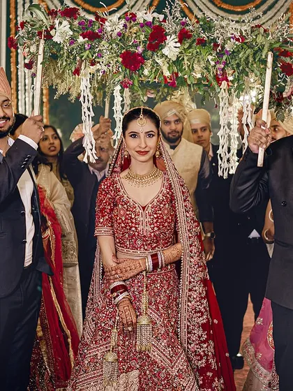 The bride makes her way to the mandap under a beautiful 'phoolon ki chaadar' held by her brothers. A classic and emotional moment.