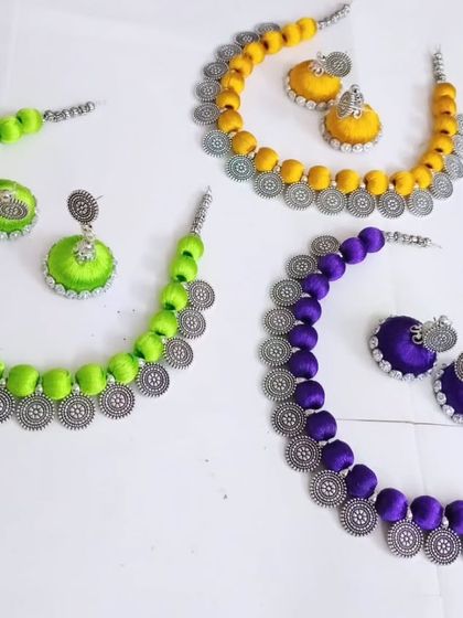 Another view of the custom silk thread necklace sets, showcasing the beautiful oxidized silver charms that complement the colorful threads.