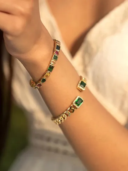 A close-up of the emerald and multi-colored cuff bangles. The perfect combination of classic and contemporary.