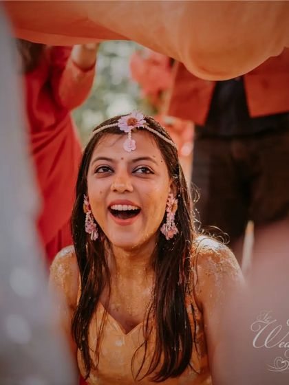 The bride's ecstatic expression during the 'haldi smear' ritual. These candid moments of surprise and joy are what make the ceremony so special.