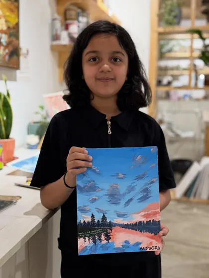 A young artist with her beautifully detailed landscape painting. In our sessions, I encourage kids to explore techniques for painting things like skies, water, and reflections.