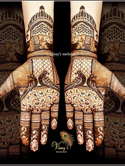 A royal design for a shorter mehndi look. This pattern features birds on the palms and elephants in jharokhas on the wrists.