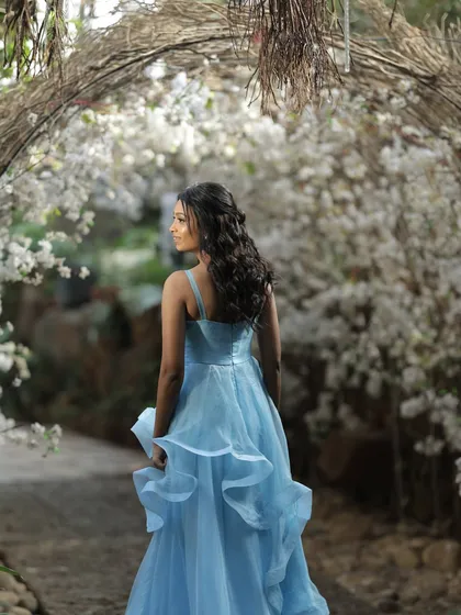 The bride-to-be looking like a princess in her pastel blue gown, walking through the 'Garden of Promises' I designed for her brunch. The archway of white flowers creates a truly ethereal portrait.