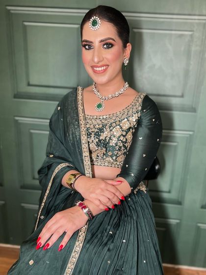 A full look at this gorgeous party guest. The sleek bun and emerald green jewelry pair perfectly with the soft glam makeup, creating a look that is both sophisticated and stylish.