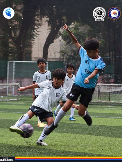 A player jumps to block a pass, showing great anticipation and athleticism during a Mumbai league match.