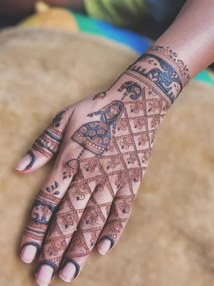 A graceful back-hand design for Gangaur, featuring a woman in traditional attire against a jaali (net) pattern. The wristband with elephant motifs adds a touch of royal elegance to the design.