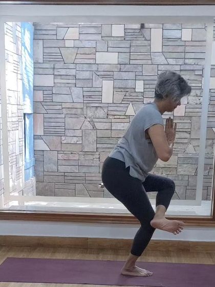 A student demonstrating a challenging balancing pose. Our classes help you build the strength and focus needed for such asanas.