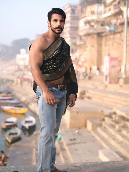 A strong and confident portrait on the edge of the ghats, overlooking the boats on the Ganga, blending contemporary style with the timeless spirit of Banaras.