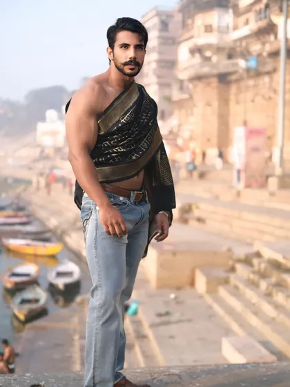 A strong and confident portrait on the edge of the ghats, overlooking the boats on the Ganga, blending contemporary style with the timeless spirit of Banaras.