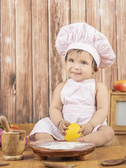 A sweet little chef girl, looking thoughtful as she plays with her ingredients.