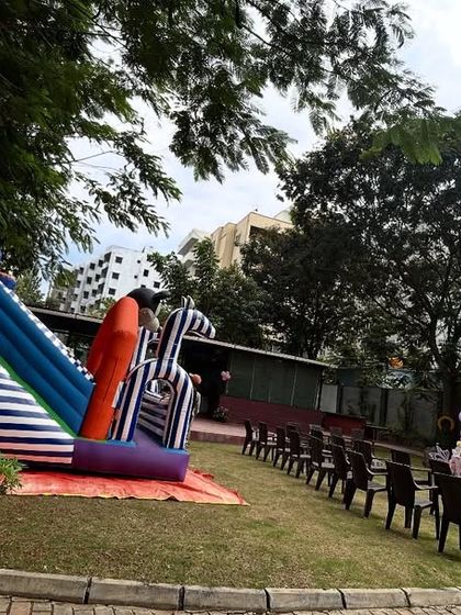 Another view of the outdoor party space, showing the bouncy castle and seating arrangement for guests.