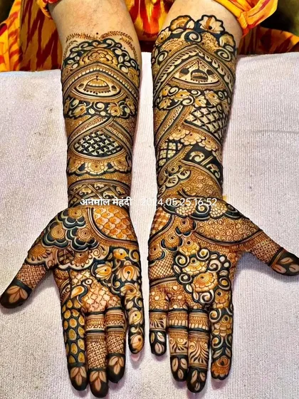 This is a very dense and intricate 'full-fill' mehendi design. The use of negative space is minimal, creating a rich tapestry of patterns that completely covers the hands and arms.