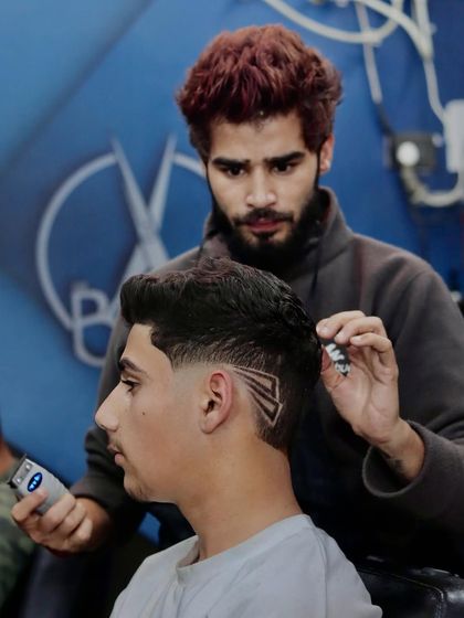 A rockstar haircut. This image shows me adding the finishing touches to a creative razor design on a young client.