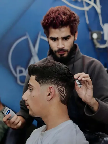 A rockstar haircut. This image shows me adding the finishing touches to a creative razor design on a young client.