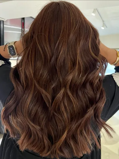 An auburn honey blend that adds warmth and richness. The soft layered haircut complements the color, creating a look that's both healthy and vibrant.