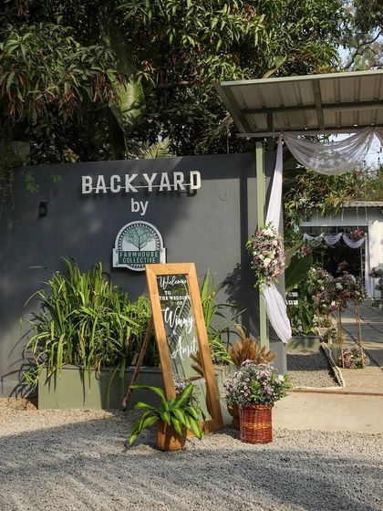 The welcoming entrance to Backyard by FHC, set for an intimate wedding. The sign and floral arrangements guide guests into this private, modern space designed for smaller celebrations.