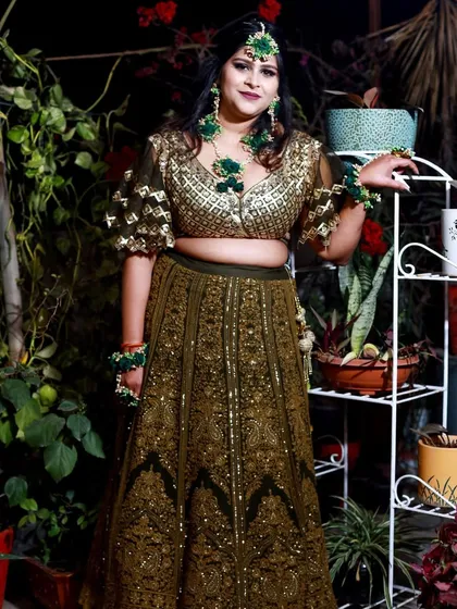 A confident and happy pose from the bride during her Mehndi ceremony. The outdoor setting adds a fresh and natural feel to the photograph.