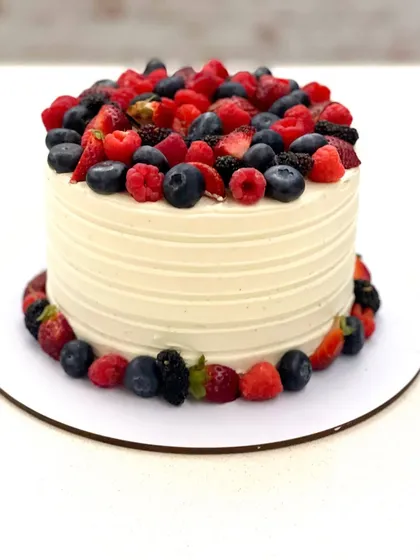 Another shot of the fresh berry cake, showcasing the vibrant colors of the strawberries, blueberries, and raspberries.