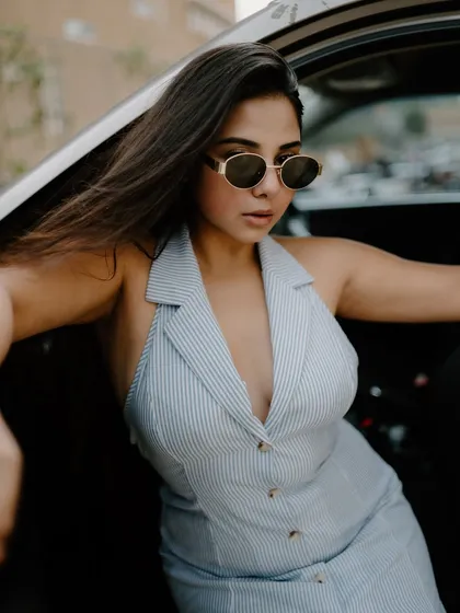 A creative portrait shot through a car window. The reflections and the model's pose create an artistic and moody fashion image.