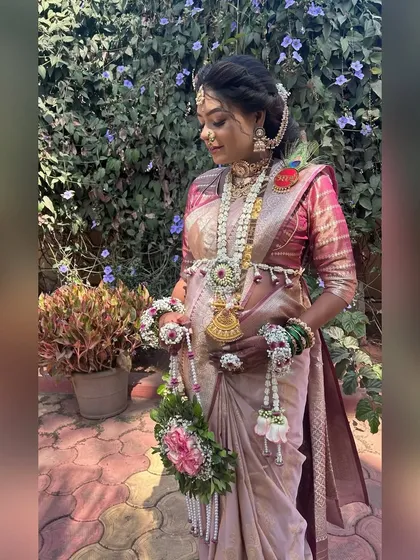 A beautiful outdoor shot of a mom-to-be in her custom floral jewellery, including a necklace, kamarband, and a matching floral purse.