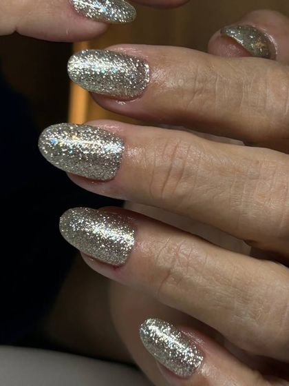 A full-coverage silver glitter manicure. The high-density glitter provides an opaque, incredibly sparkly finish that is perfect for making a statement.
