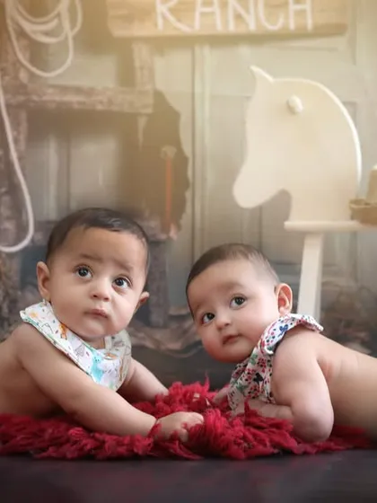 Tummy time at the ranch. Capturing milestones like learning to push up is even more fun with a creative theme, like this cowboy setup for six-month-old twins.