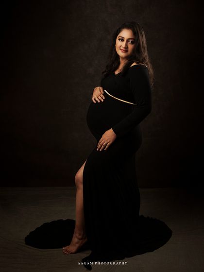 A full-length view shows the elegant silhouette of the black gown. The simplicity of the shot puts all the focus on her and her beautiful bump.