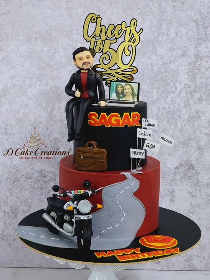A full view of the two-tier biker-themed cake, complete with a handcrafted motorcycle and a road winding up the side.