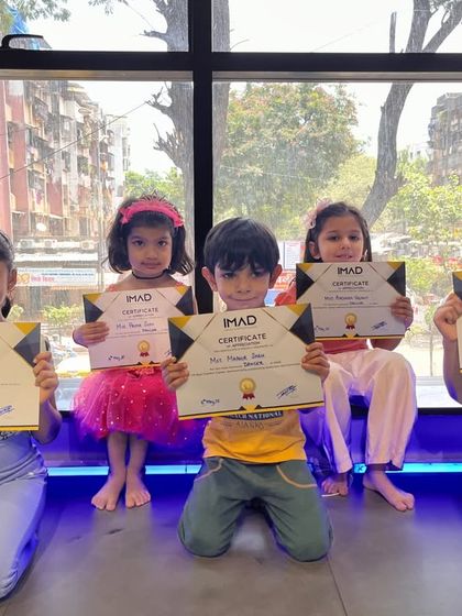 A group of our younger gymnasts proudly displaying their IMAD certificates. Our programs are designed for kids of all ages, with a focus on fun and achievement.