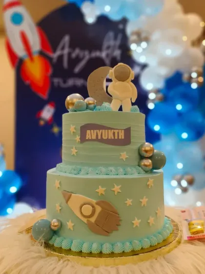 The full view of the space-themed cake, complete with a fondant astronaut, moon, and rocket ship.