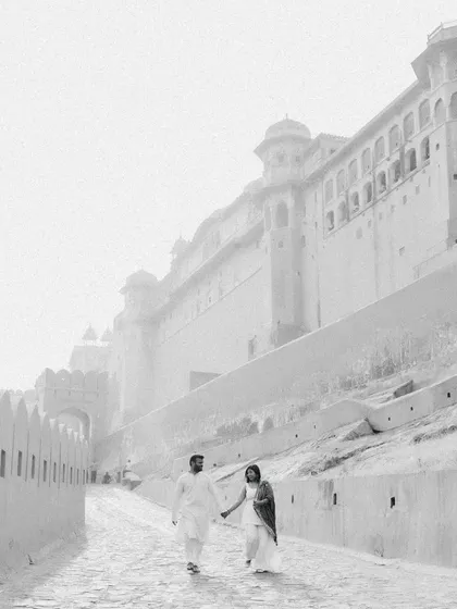 A beautiful black and white shot of a couple walking towards Amer Fort in Jaipur. The misty, high-key effect gives it a dreamy, ethereal quality, as if they are walking into a legend.