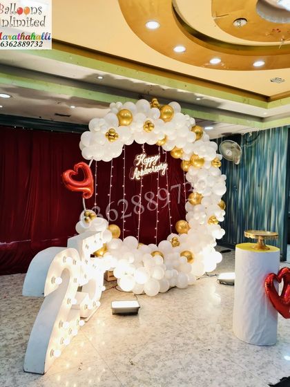 Another view of the beautiful 25th anniversary setup, highlighting the 'Happy Anniversary' sign and the romantic red curtain backdrop.