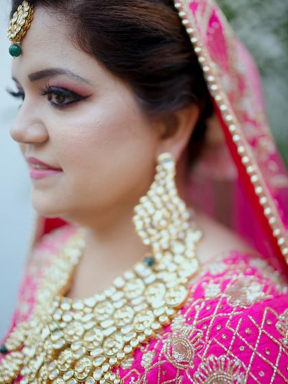 A close-up portrait of the bride, highlighting her flawless makeup and magnificent jewelry. Her expression is one of calm and happy anticipation.
